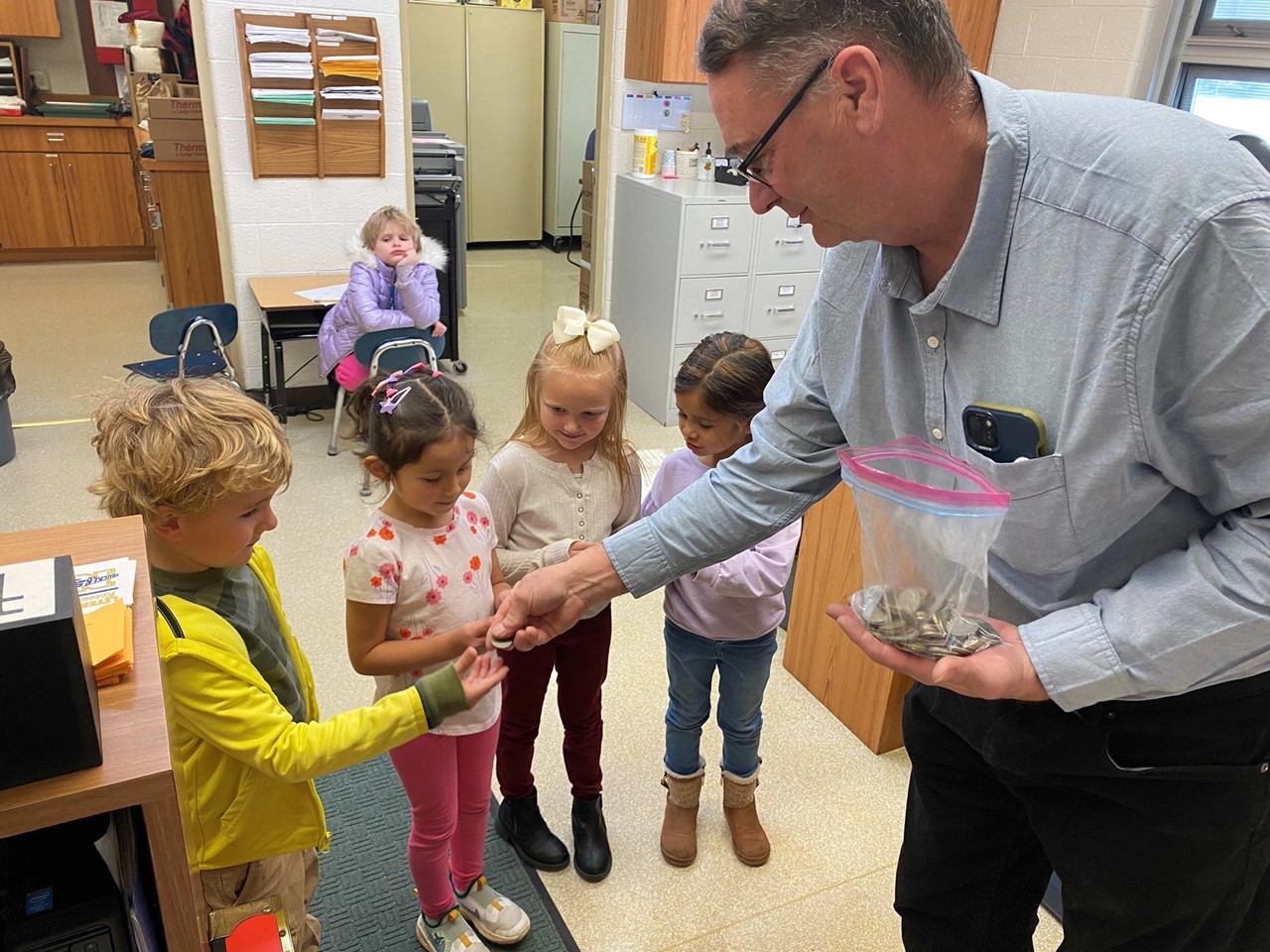 Veteran Don Ratliff shares coins with students from his collection.