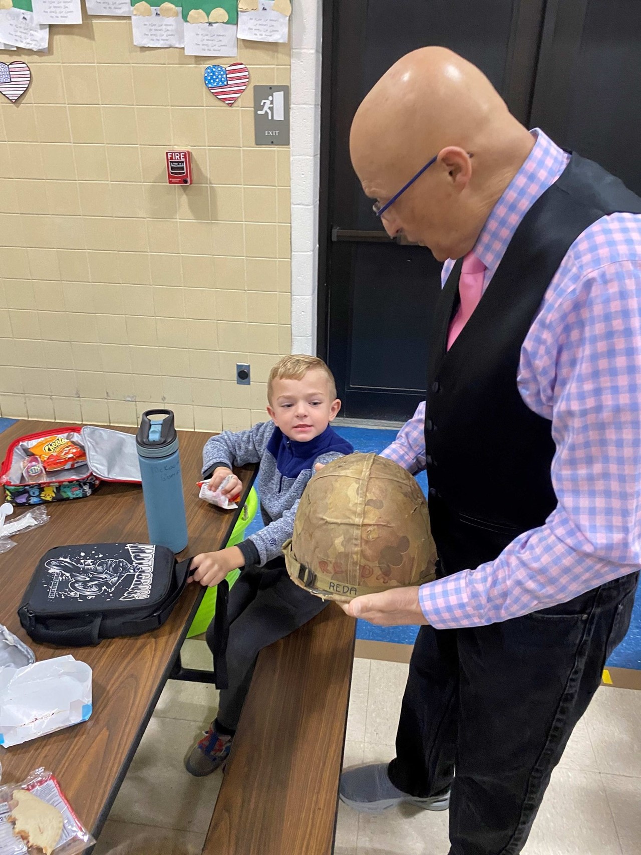 Veteran Lou Reda shows his helmet to McKaden Querin.